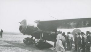 Several individuals standing around an airplane piloted by Amelia Earhart. 